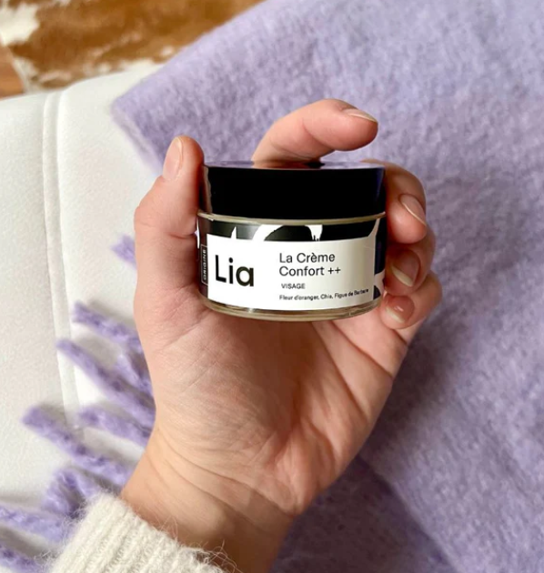 une main qui tient un pot de crème de la marque princesse Lia